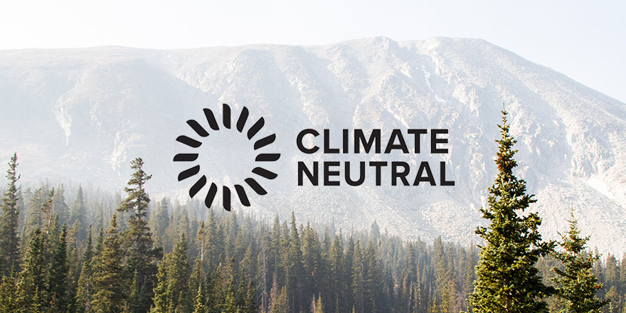 Climate Neutral Committed logo with mountains and trees in background.
