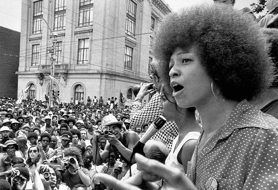 Image of Angela Davis at a protest speaking to a crowd of people